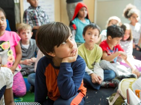 Young children listen to a classroom lesson.